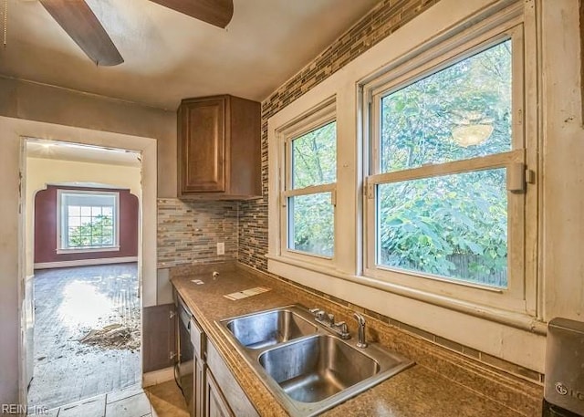 kitchen with ceiling fan, sink, decorative backsplash, and stainless steel dishwasher