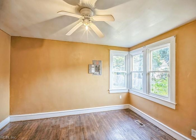 spare room featuring hardwood / wood-style flooring, ceiling fan, and a wall mounted air conditioner