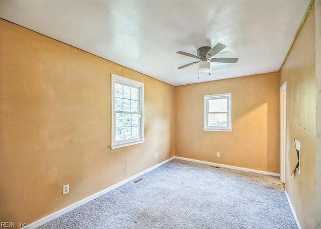 carpeted spare room with ceiling fan and a healthy amount of sunlight