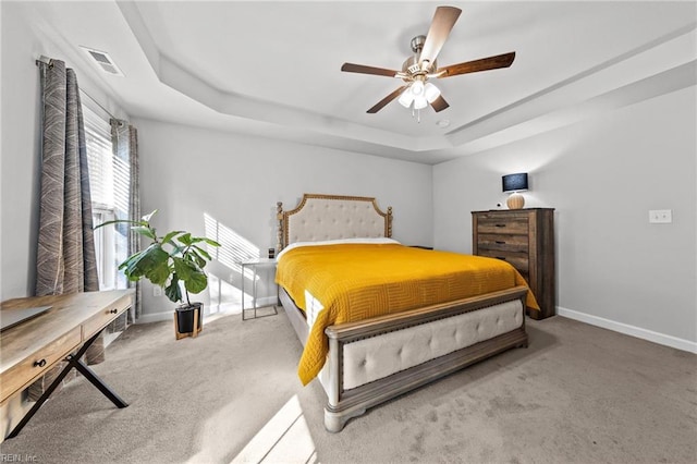 bedroom featuring a raised ceiling, carpet flooring, and ceiling fan