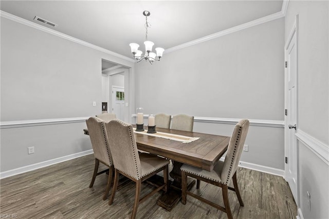 dining area featuring dark wood-type flooring, crown molding, and a chandelier