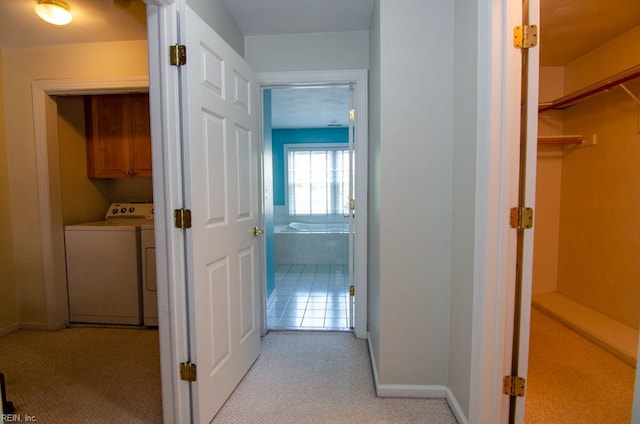 hallway featuring light carpet and washer / clothes dryer