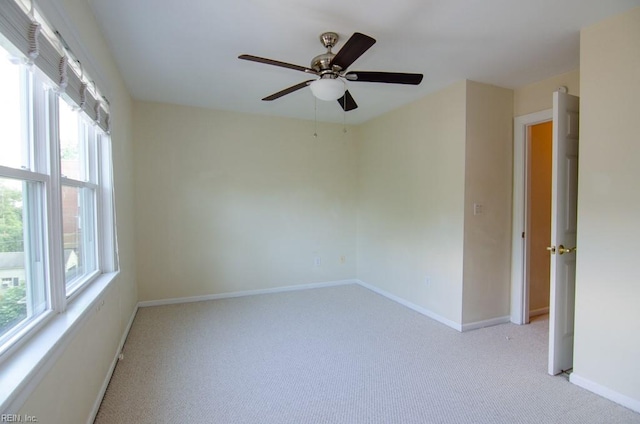 spare room with light carpet and ceiling fan