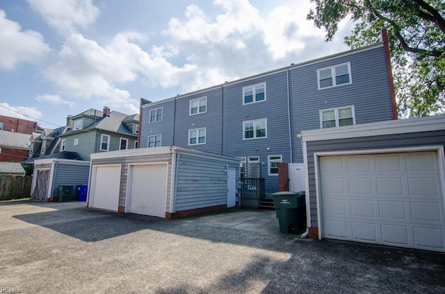 exterior space featuring a garage and an outbuilding