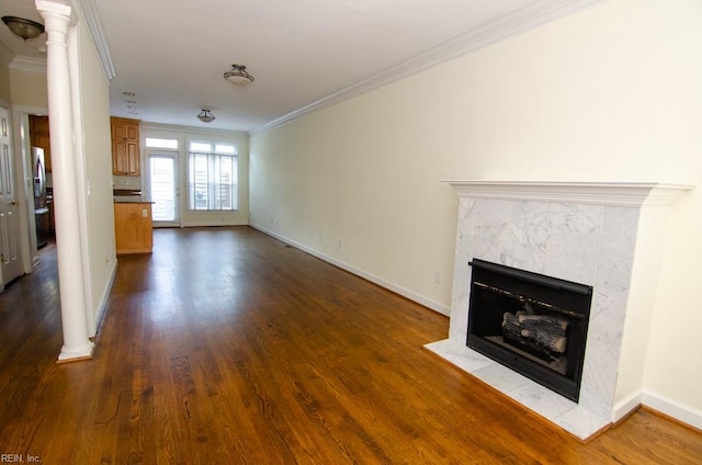 unfurnished living room featuring crown molding, a high end fireplace, dark wood-type flooring, and decorative columns