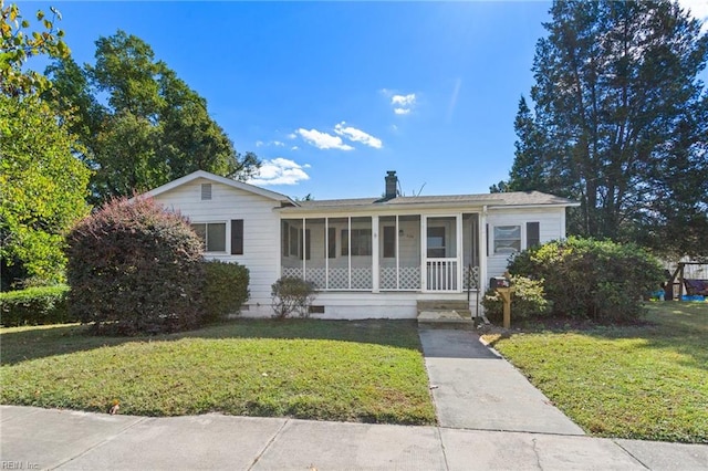 view of front facade with a front lawn and a sunroom