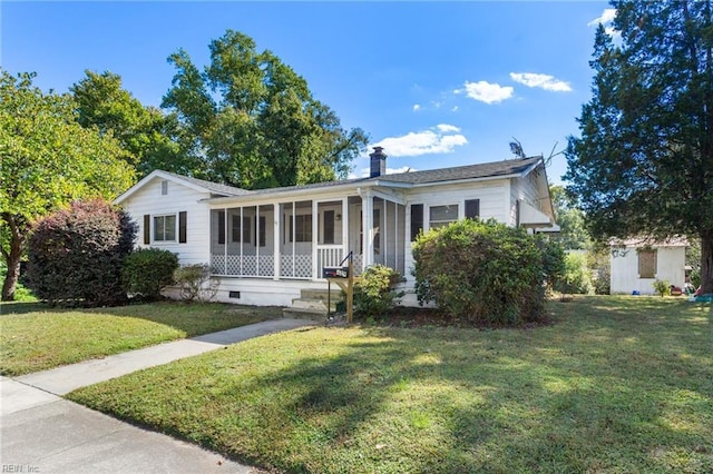 view of front of property featuring a front yard and a sunroom