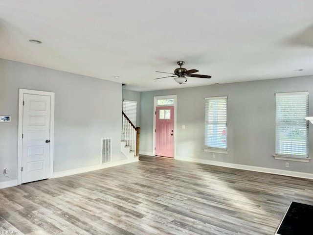 unfurnished living room with light wood-type flooring and ceiling fan