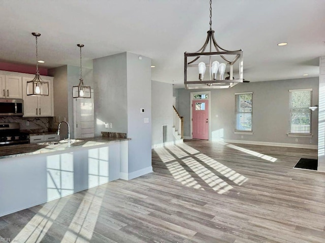 kitchen featuring hardwood / wood-style floors, pendant lighting, sink, and stainless steel appliances