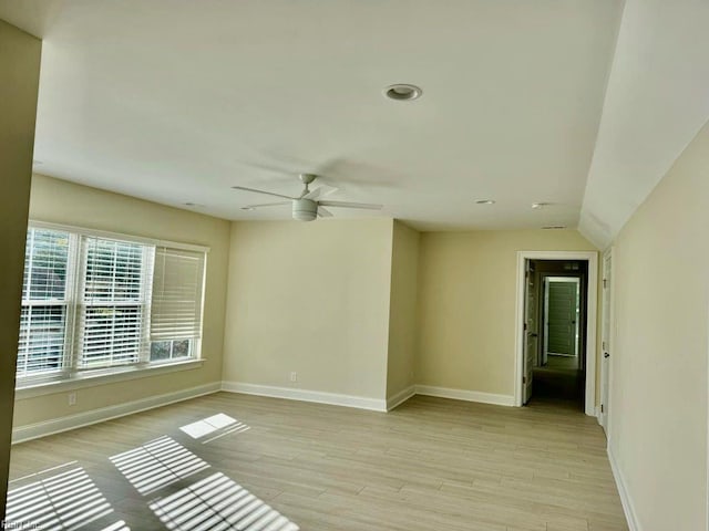 empty room featuring light hardwood / wood-style floors, ceiling fan, and vaulted ceiling