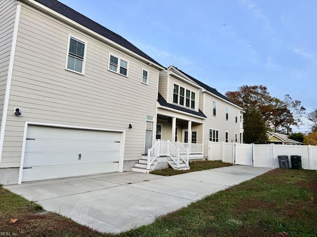 back of house featuring covered porch and a garage