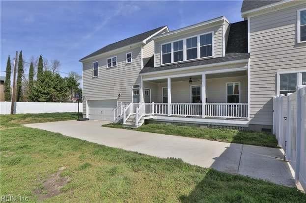 view of front of property featuring a front lawn, covered porch, and a garage