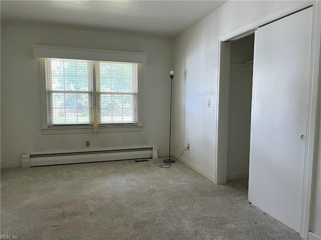 unfurnished bedroom featuring baseboard heating, light carpet, and a closet