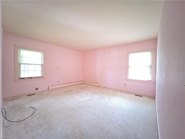 spare room with baseboard heating and light colored carpet