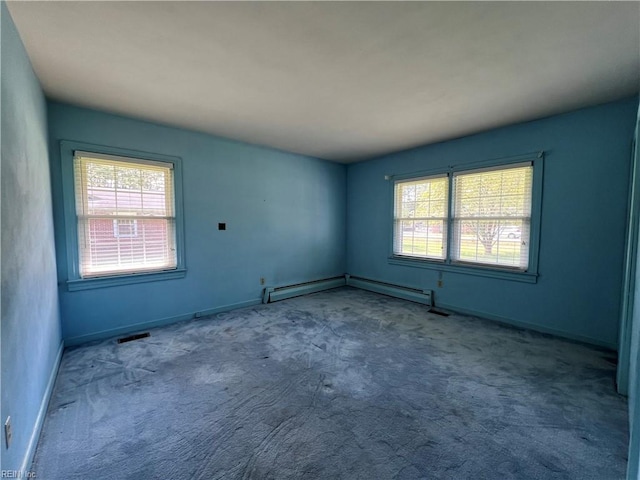 carpeted spare room featuring a healthy amount of sunlight and baseboard heating