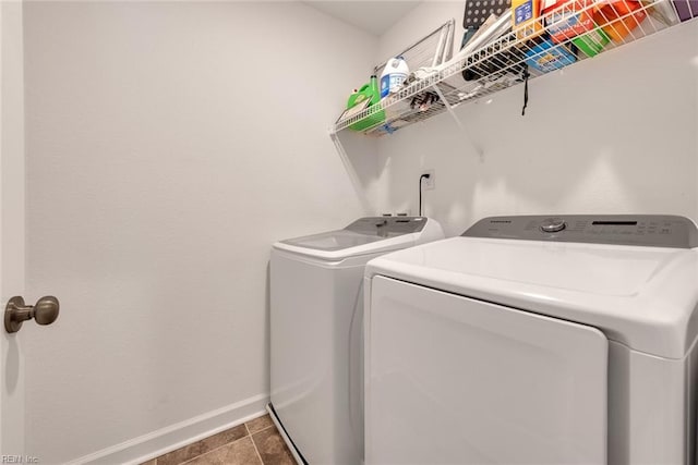 washroom with washer and dryer and dark tile patterned flooring