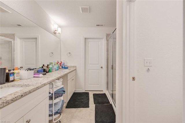 bathroom with a shower with door and vanity