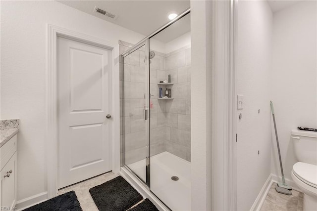 bathroom featuring toilet, an enclosed shower, vanity, and tile patterned flooring