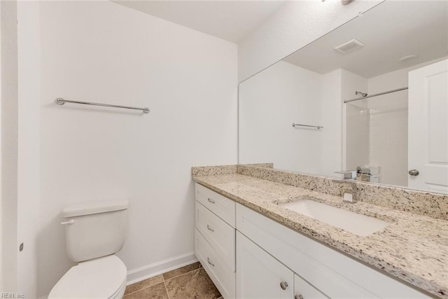 bathroom with vanity, a shower, and toilet