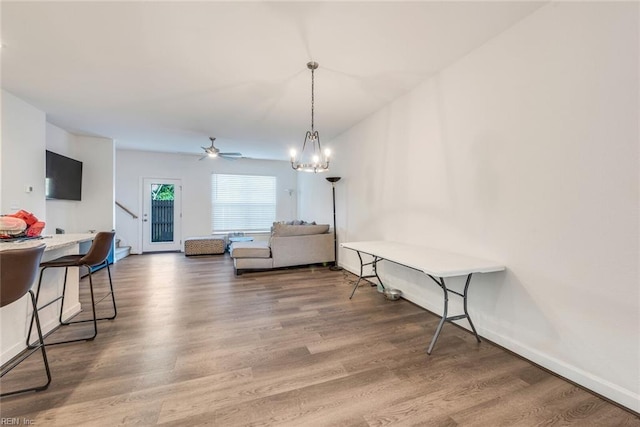 interior space featuring hardwood / wood-style floors and ceiling fan with notable chandelier