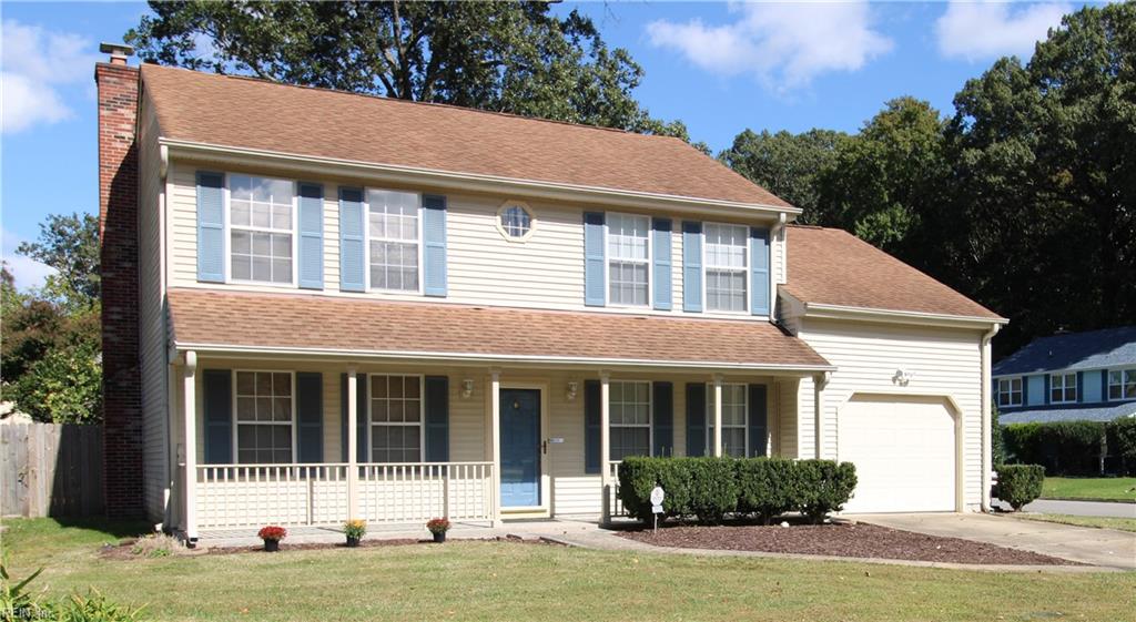 colonial inspired home featuring a porch and a front lawn