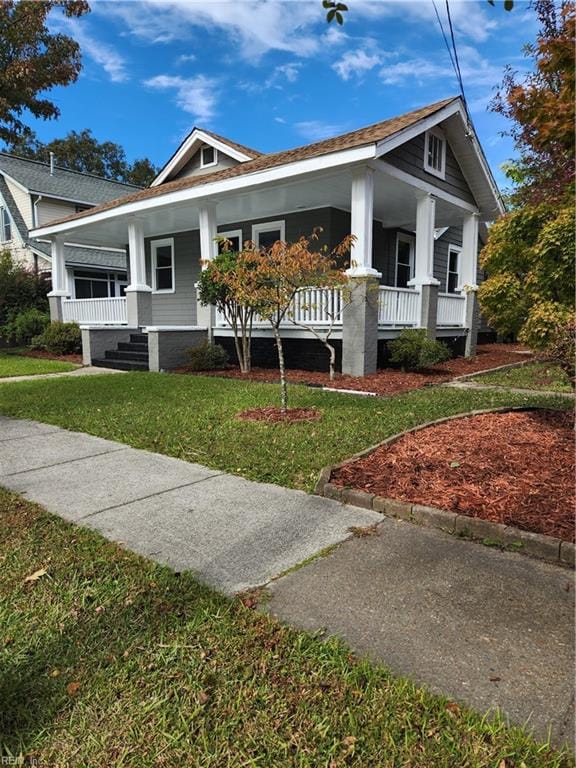 view of front of property with a porch and a front lawn