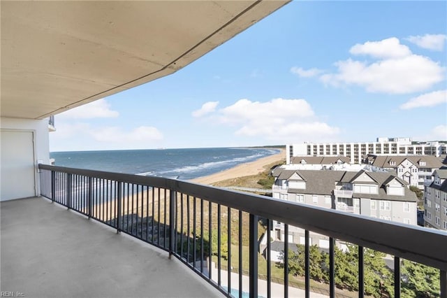 balcony with a water view and a view of the beach