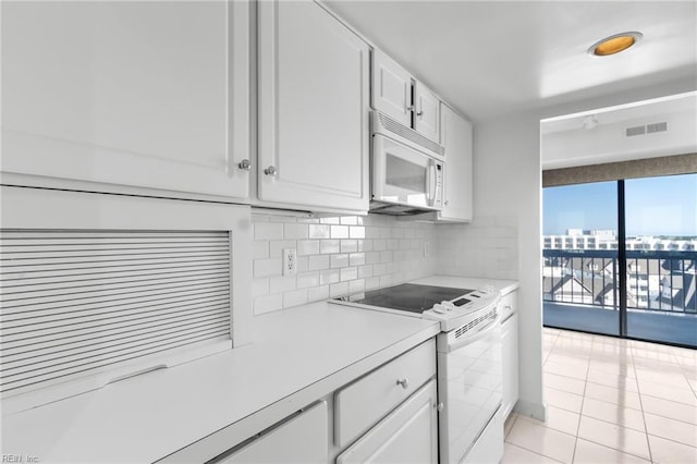 kitchen with white appliances, backsplash, light tile patterned floors, and white cabinets