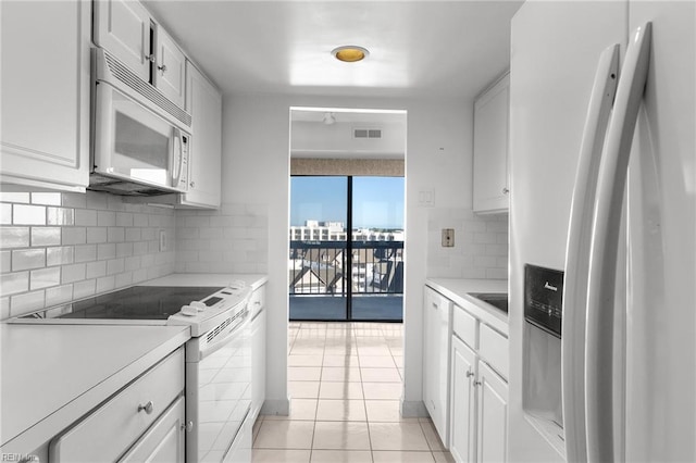 kitchen featuring backsplash, white cabinetry, white appliances, and light tile patterned flooring