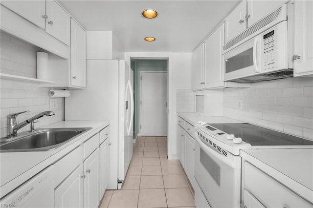 kitchen featuring white cabinets, sink, light tile patterned floors, and white appliances