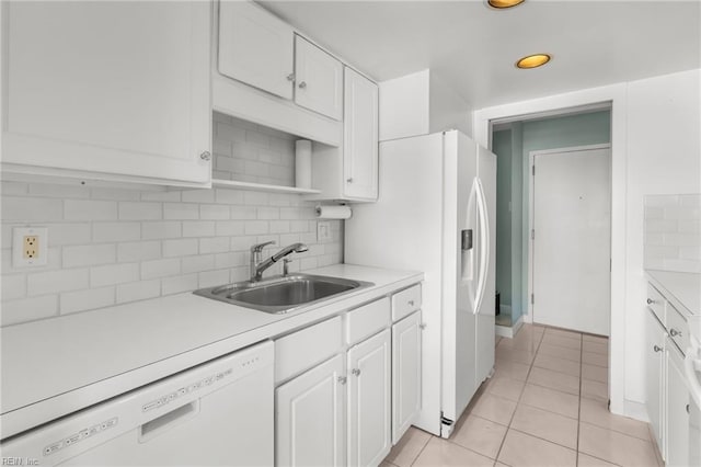 kitchen with white appliances, white cabinetry, sink, and decorative backsplash