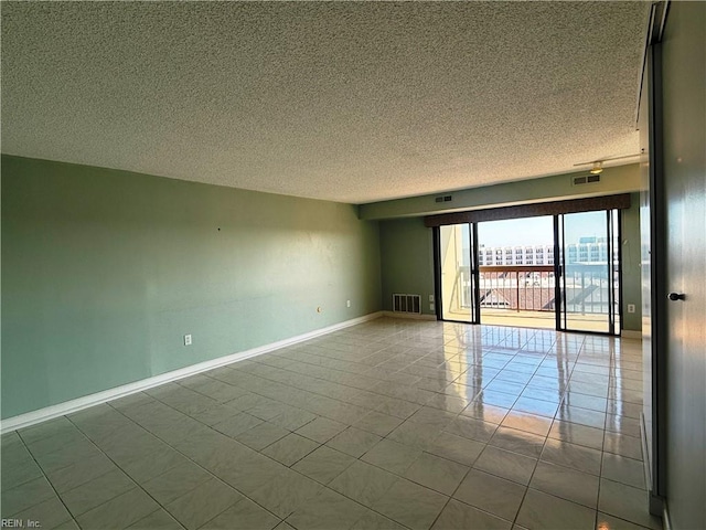 tiled empty room with a textured ceiling