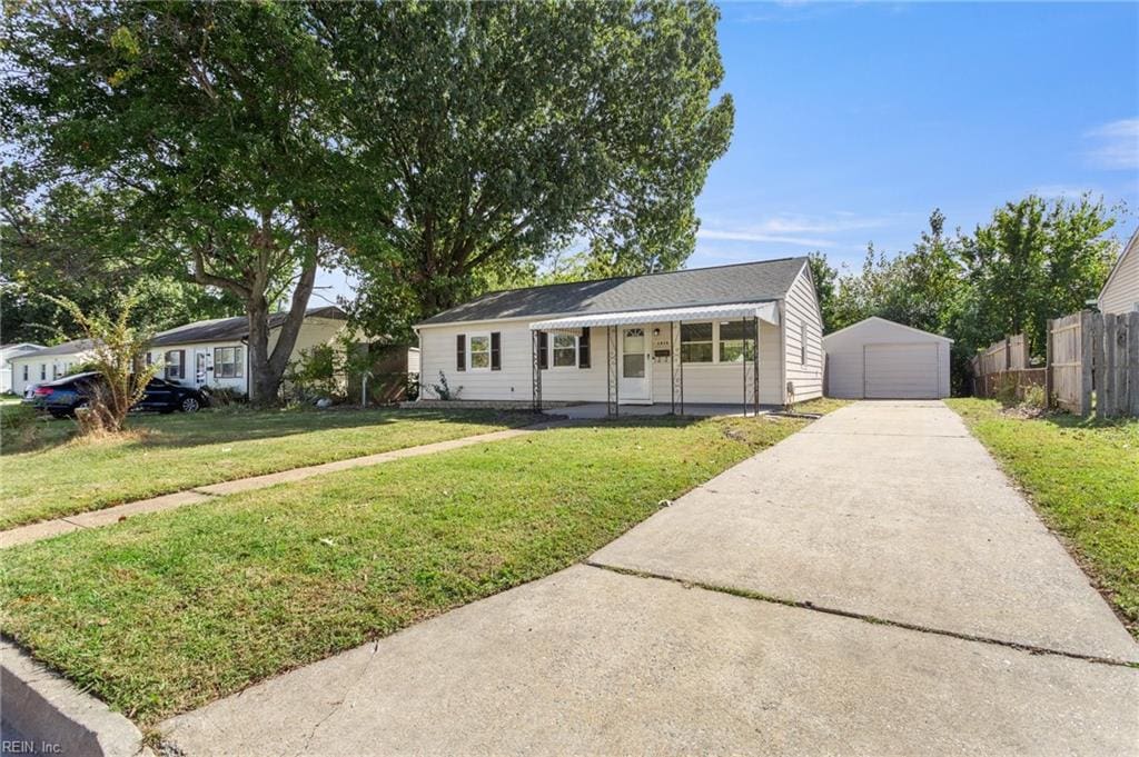 single story home with an outdoor structure, a garage, and a front lawn