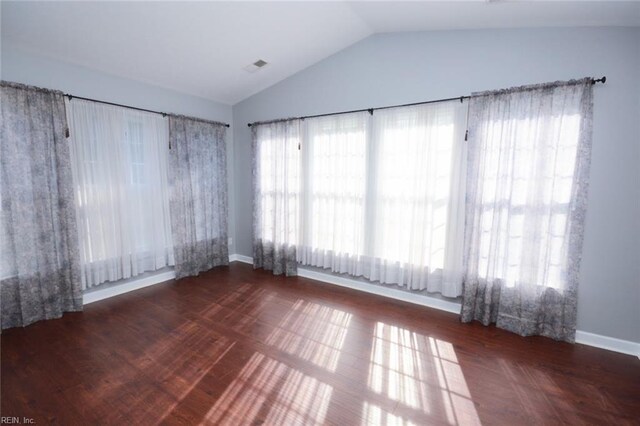 empty room featuring lofted ceiling and dark wood-type flooring