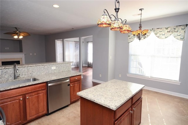 kitchen with dishwasher, a kitchen island, sink, pendant lighting, and light stone counters