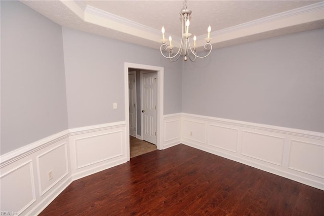 spare room featuring crown molding, dark hardwood / wood-style floors, and a chandelier