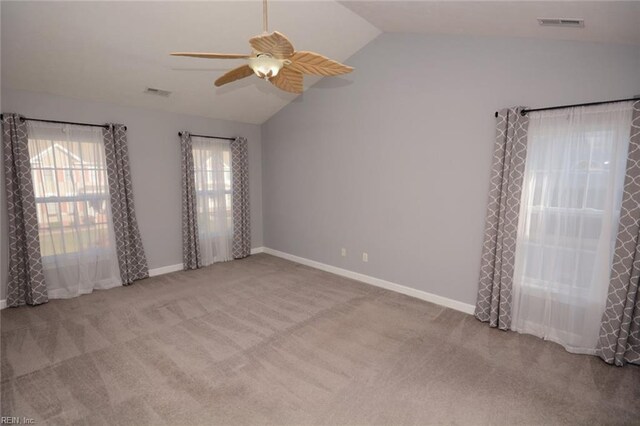 spare room featuring vaulted ceiling, light colored carpet, and ceiling fan