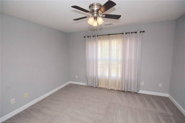 empty room featuring light colored carpet and ceiling fan