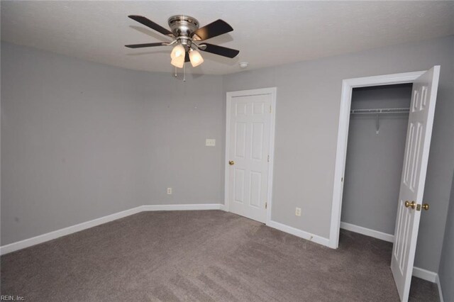 unfurnished bedroom featuring ceiling fan and dark carpet