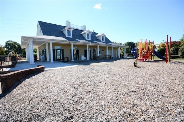 rear view of house with a patio and a playground