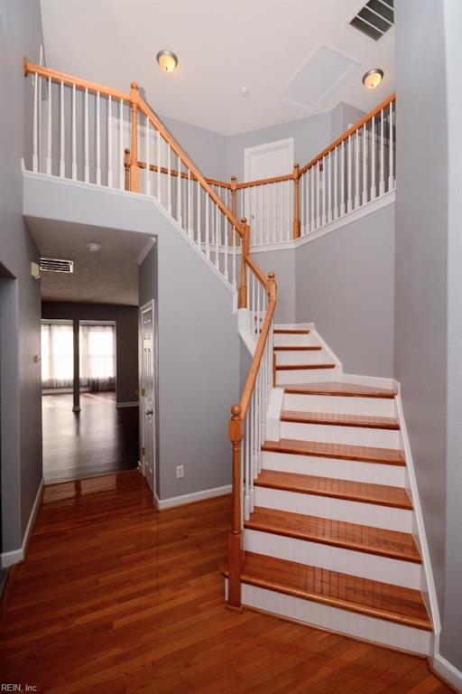 staircase with hardwood / wood-style flooring and a high ceiling