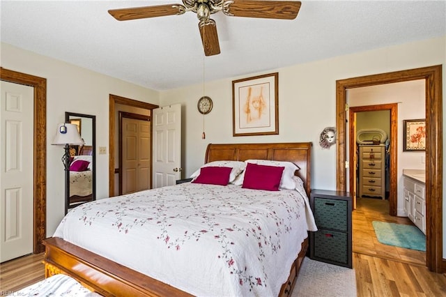 bedroom with light hardwood / wood-style flooring, connected bathroom, and ceiling fan