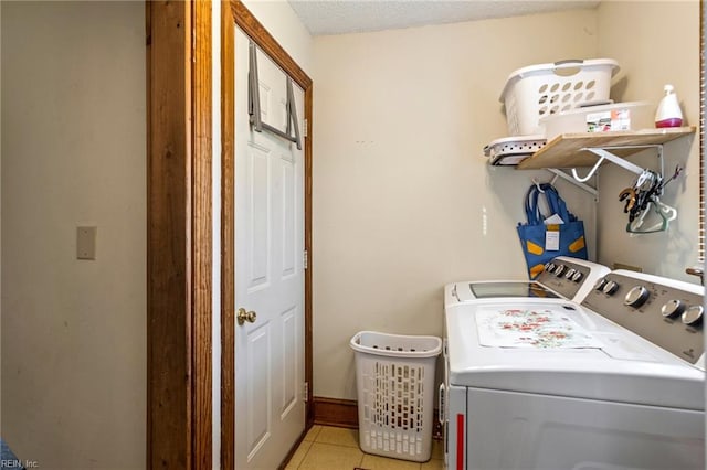 washroom featuring a textured ceiling, light tile patterned flooring, and separate washer and dryer