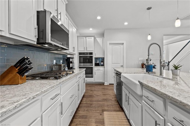 kitchen featuring white cabinetry, appliances with stainless steel finishes, dark hardwood / wood-style flooring, and decorative light fixtures