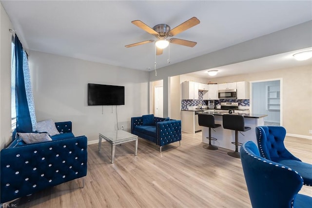 living room with ceiling fan and light wood-type flooring