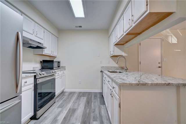 kitchen with light hardwood / wood-style floors, stainless steel appliances, and white cabinets