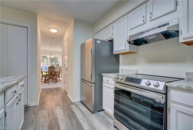 kitchen featuring light stone countertops, white cabinetry, stainless steel appliances, and light wood-type flooring