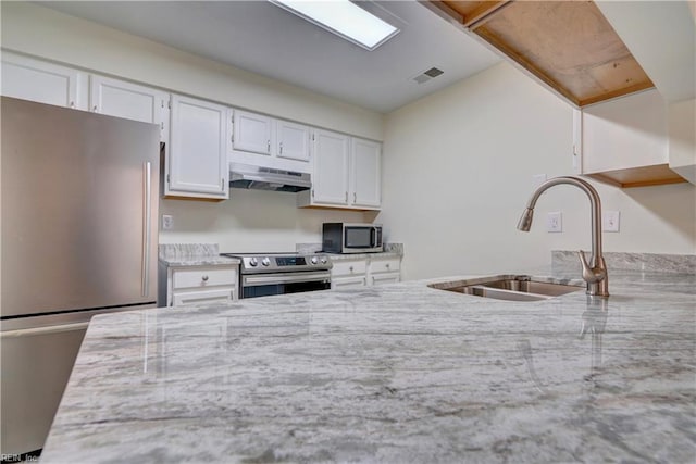 kitchen featuring white cabinetry, light stone counters, stainless steel appliances, and sink