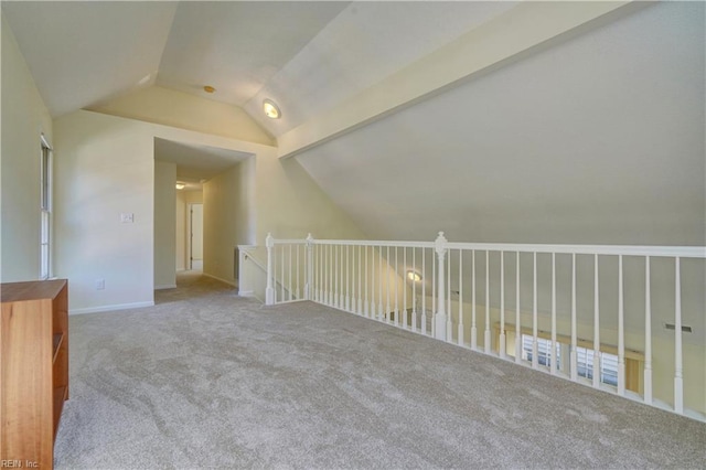 additional living space featuring lofted ceiling with beams and carpet flooring