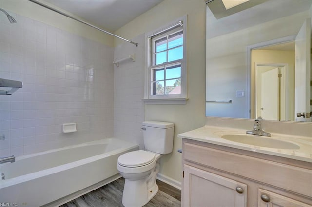 full bathroom with tiled shower / bath, vanity, wood-type flooring, and toilet